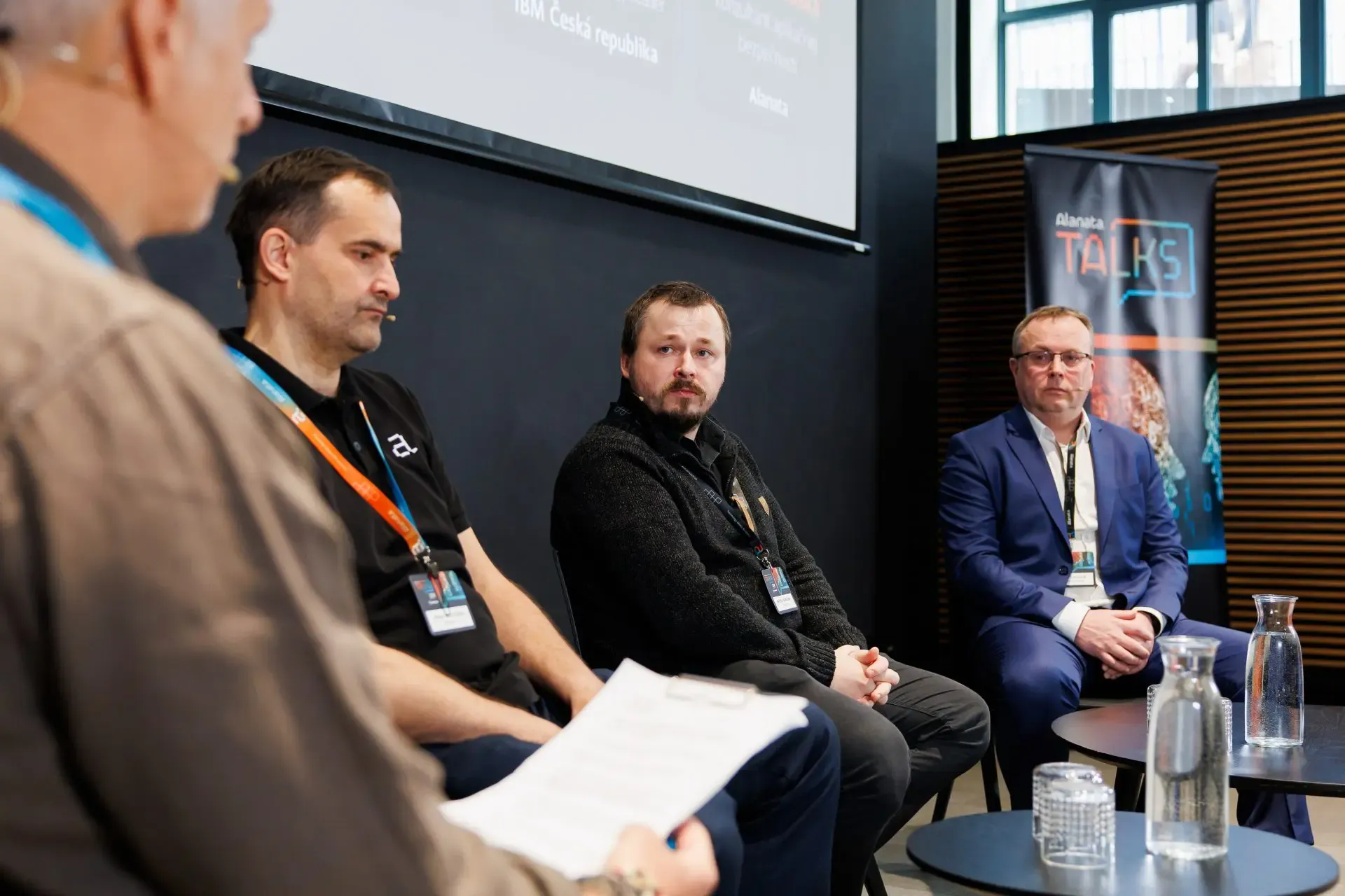 Four speakers seated during a panel at Alanata TALKS
