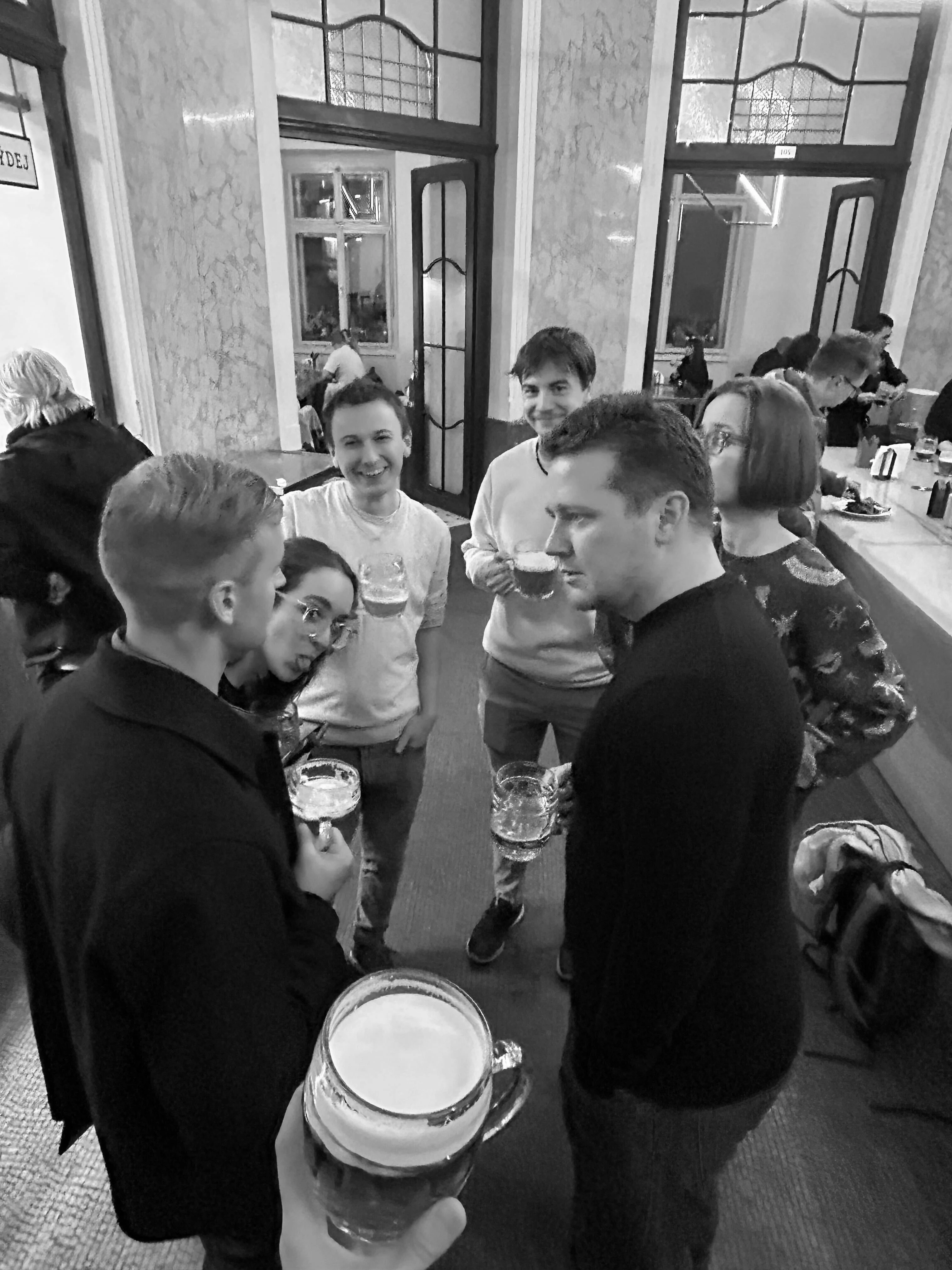 Colleagues chatting over drinks at an indoor event.